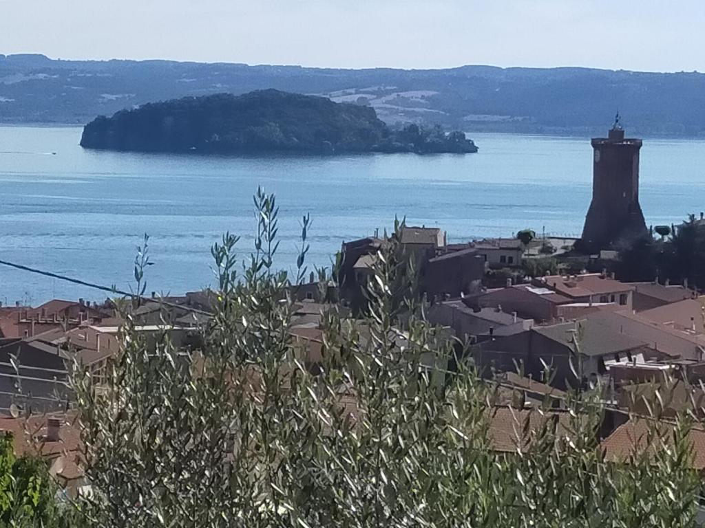 Blick auf eine Stadt mit einem Leuchtturm auf dem Wasser in der Unterkunft Appartamento 2 a Marta nel Lago di Bolsena in Marta