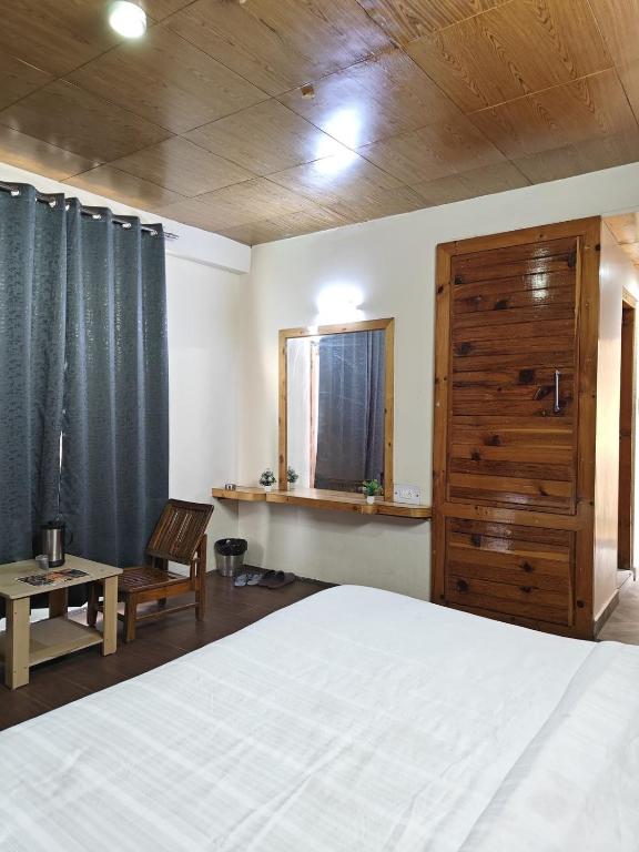 齐拉克普尔Hotel New Infraview - luxuries rooms with Cooled AC的一间卧室，里面有一张床、一把椅子和一扇窗户