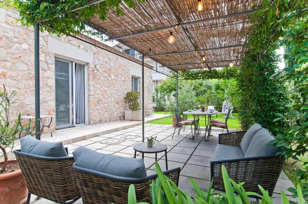 an outdoor patio with chairs and tables and a pergola at Stelle Galeotte Exclusive Holiday Home in Fondi