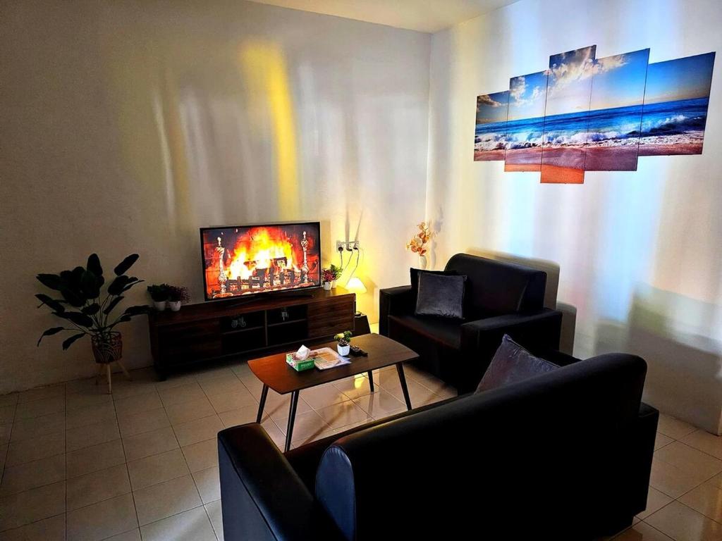 a living room with two chairs and a television at Blue House Kampar 3BR Family Suite-Kids Playroom Near UTAR in Kampar