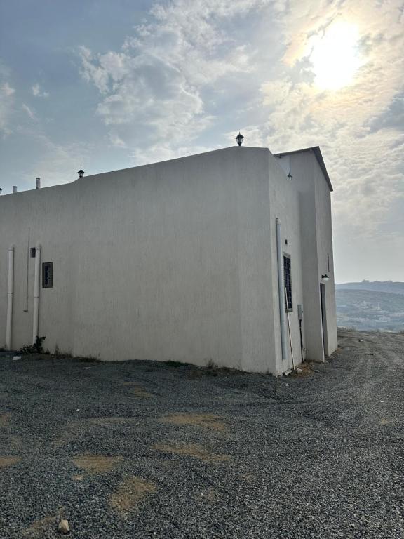 a white building with the door open on the side at فيلا بحوش خاص in Al Baha