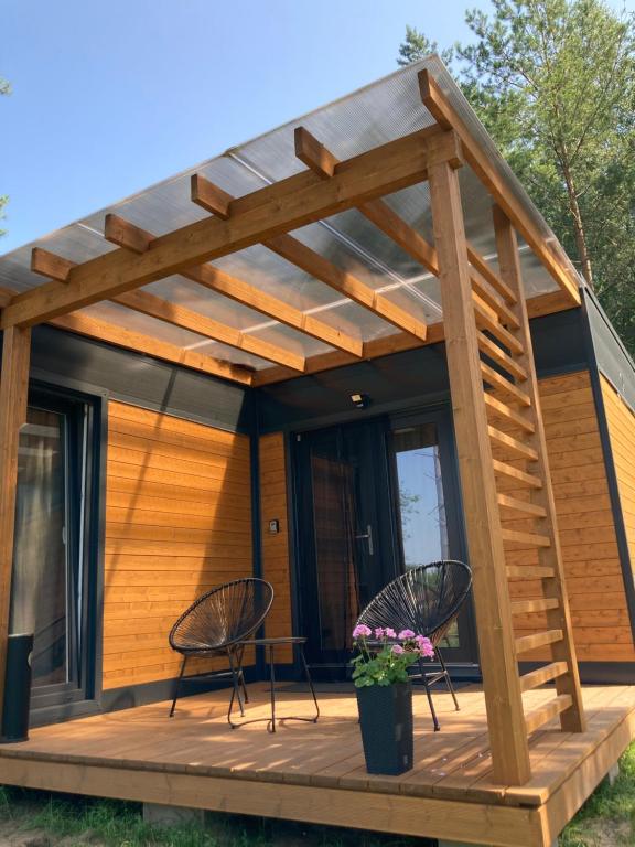 una casa con una terrazza e due sedie di Cisy Resort II-bon turystyczny,ogrodzony teren na wyłączność,150 m od jeziora a Krzywe