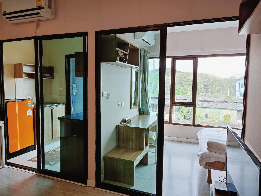 チェンマイにあるDeluxe Room at Tree Boutique Condo by Suwan Style Agencyのガラスの引き戸とキッチンが備わる客室です。