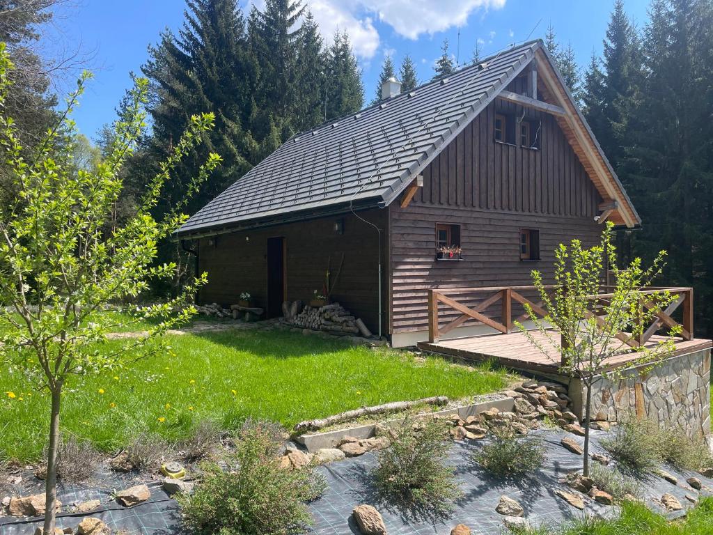 a log cabin with a deck in a yard at Hájenka Libín in Prachatice