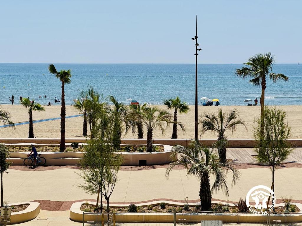 una spiaggia con palme e l'oceano di Le grand bleu a Narbonne
