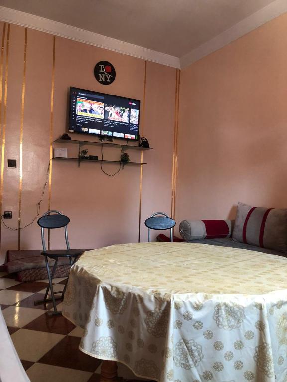 Una sala de estar con una mesa y un televisor. en Apparemment a louer à el jadida, en El Jadida