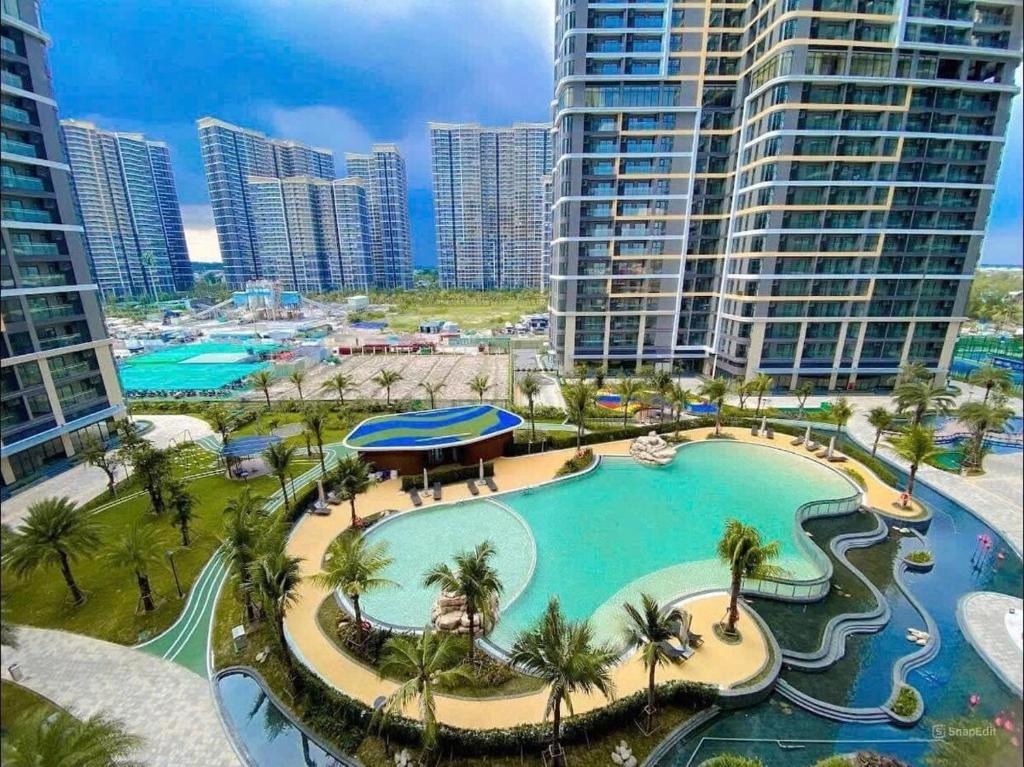 an aerial view of a resort pool with palm trees and buildings at Căn hộ Master có sofa giường view sông Đồng Nai in Long Bình