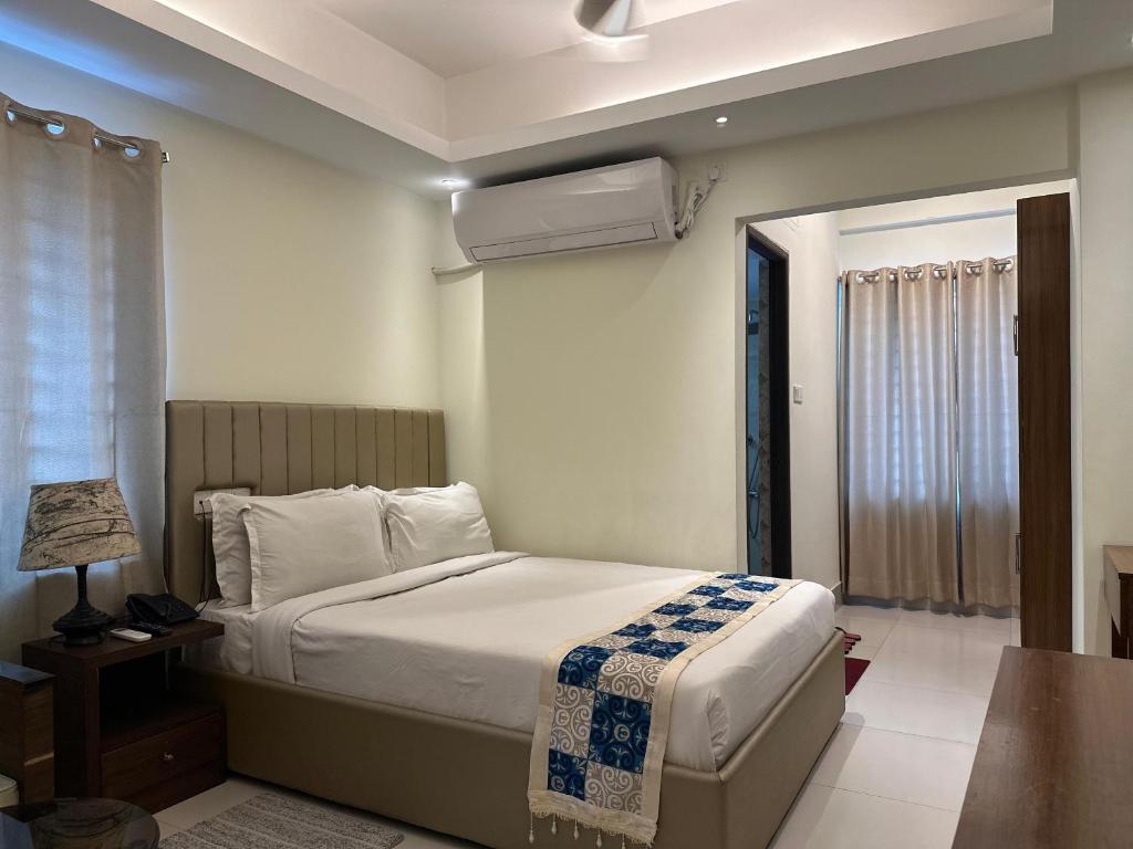 a bedroom with a bed and a table with a lamp at Hotel The Grand Hyatt Dhaka in Dhaka
