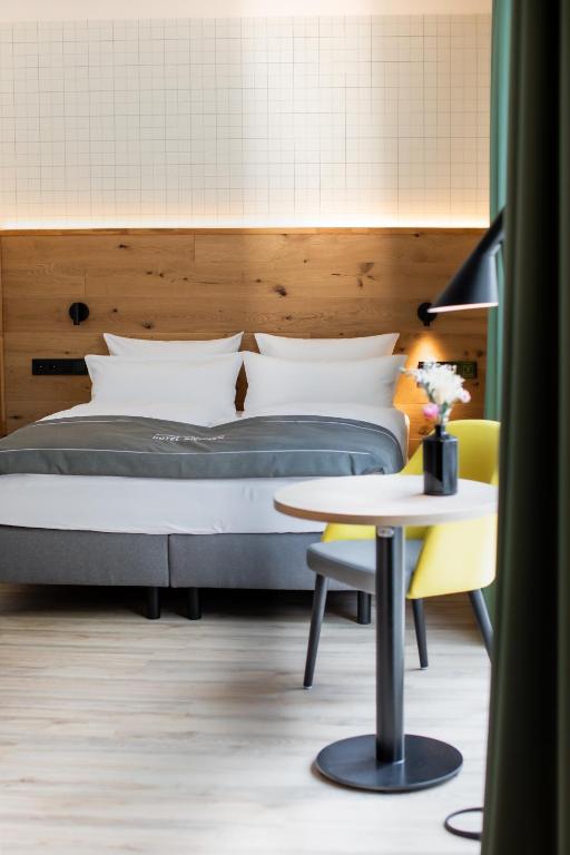 a bedroom with a bed and a table and a table sidx sidx at Hotel Nickisch in Schüttorf