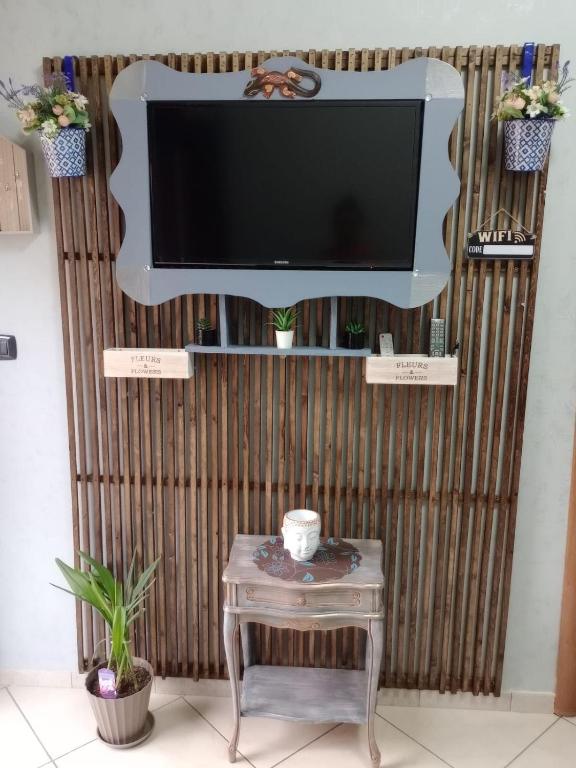 een flatscreen-tv aan een muur met een tafel bij Verti House appartamento, Frignano in Frignano