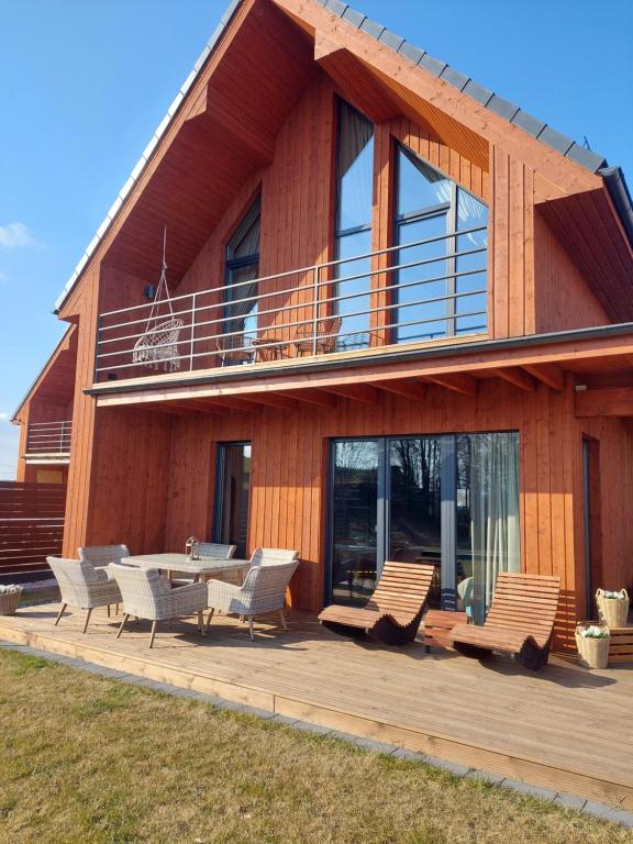 a house with a deck with chairs and a table at Widokownia Bukowinki 2 in Chmielno