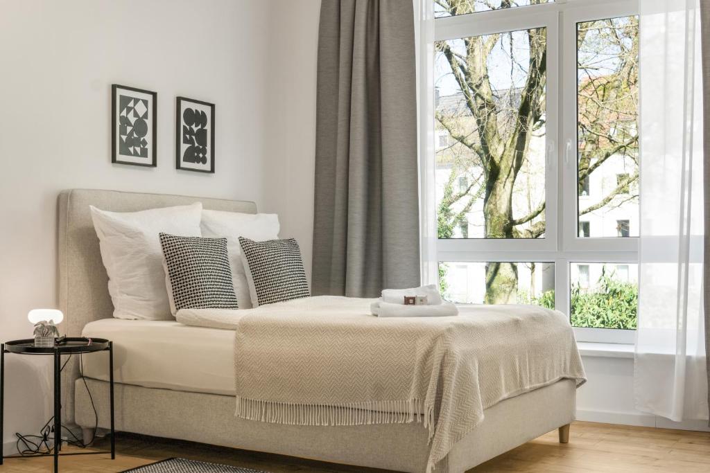 a white bedroom with a bed and a window at Loft im Herzen von Paderborn in Paderborn