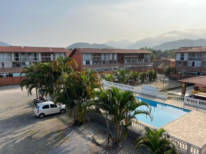 a car parked in front of a resort with a pool at Chalé Maresia Maranduba in Ubatuba