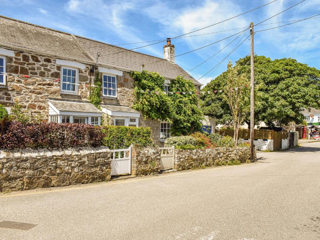 a stone house on the side of a street at Churchtown Cottage in Cubert