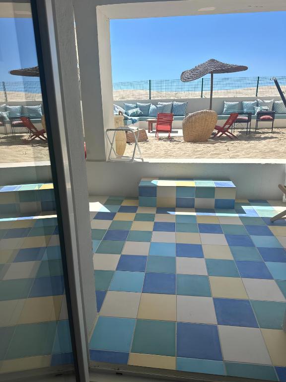 une vue sur la plage depuis une chambre avec un sol carrelé dans l'établissement La plage d'Ugo, à Mauguio