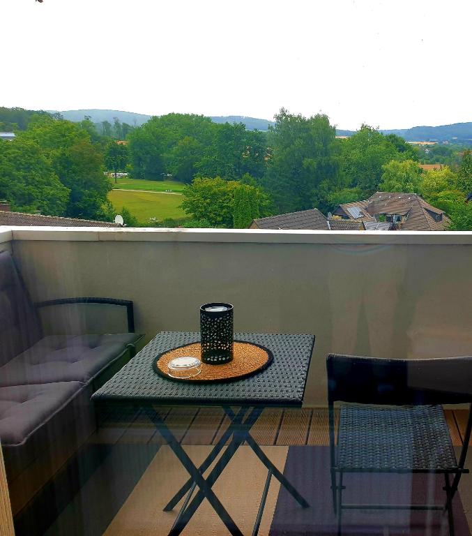 a table on a balcony with a coffee cup on it at Studio mit schöner Aussicht in Bad Rothenfelde