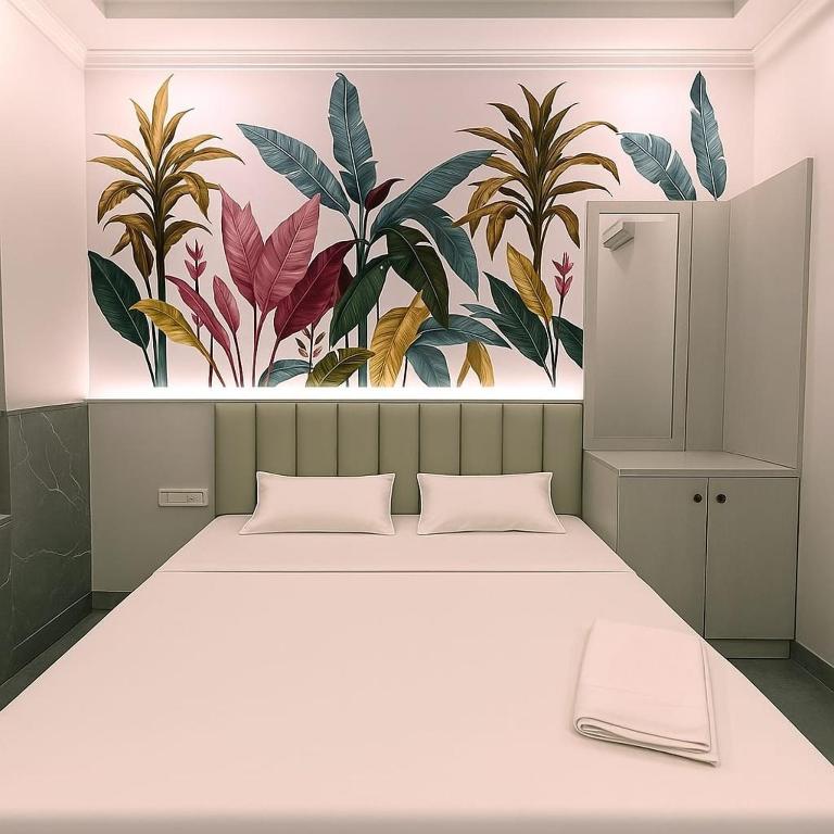 a bedroom with a large bed with a painting on the wall at Hotel Aasi inn in Nagpur