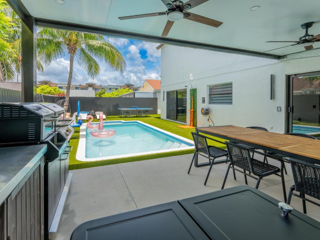 Un patio con mesa y sillas y una piscina. en Casa Madrisqui, en Homestead