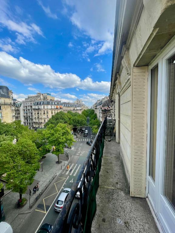 un balcon avec des voitures garées à côté d'un bâtiment dans l'établissement Appartement Convention 5 Paris, à Paris