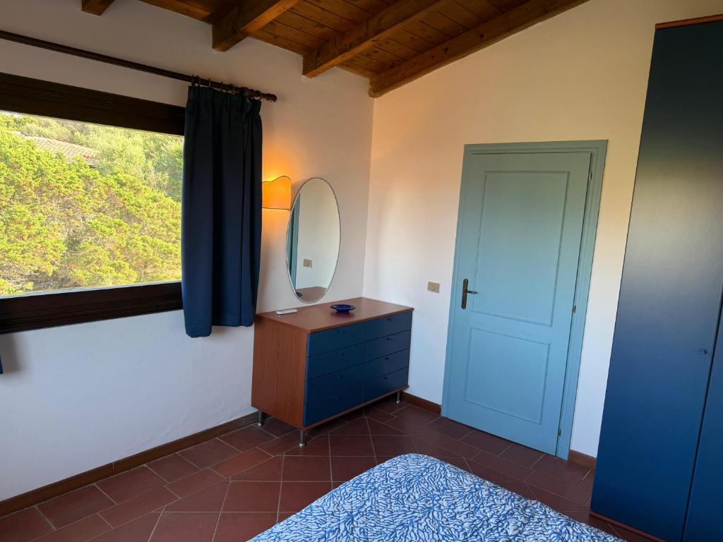 a bathroom with a mirror and a dresser and a window at Appartamento La Vela Blu in Cuile Pazzoni