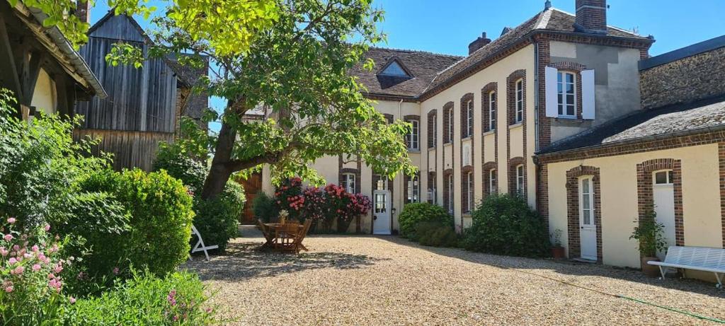 una grande casa con un cortile con una panchina di Au Clos de Charny a Charny