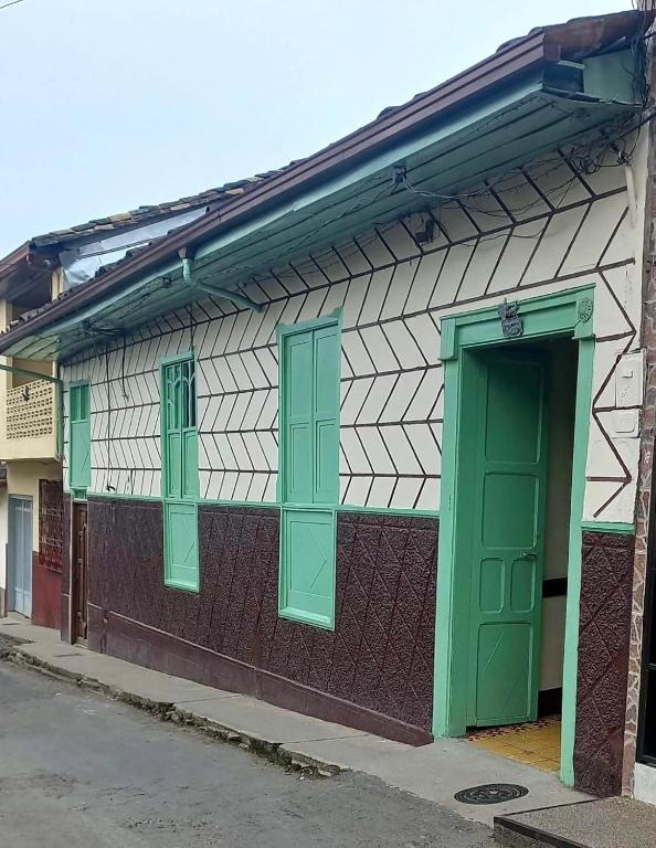 a building with green windows and a green door at Casa colonial con encanto en Sonsón in Sonsón