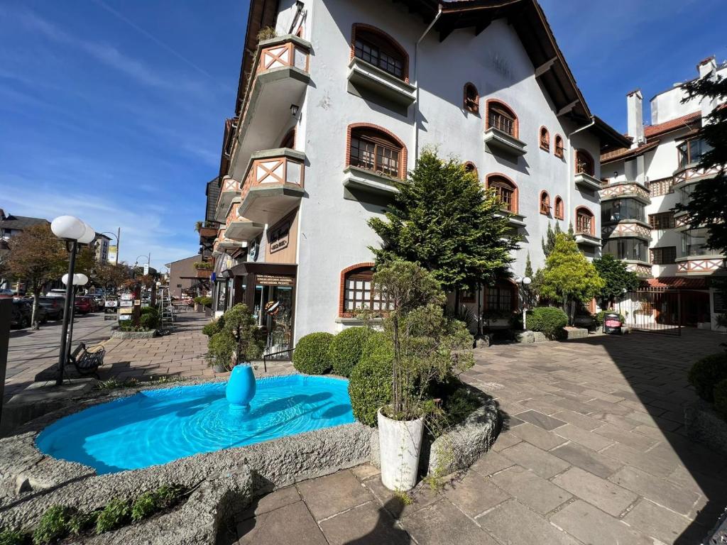 a building with a swimming pool in front of a building at Apartamento na Avenida Borges a 100 m da Rua Coberta in Gramado