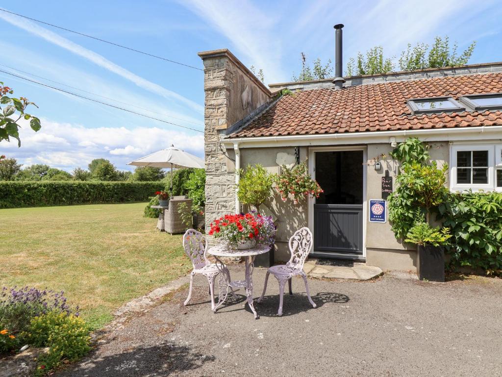 a table and chairs in front of a house at Pear Tree Cottage in Mark
