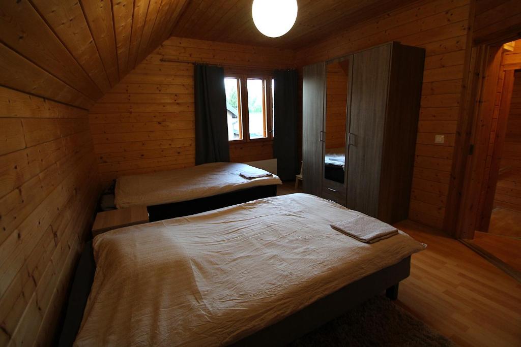 a room with two beds in a wooden cabin at Mökkitunnelmaa kaupungista in Seinäjoki