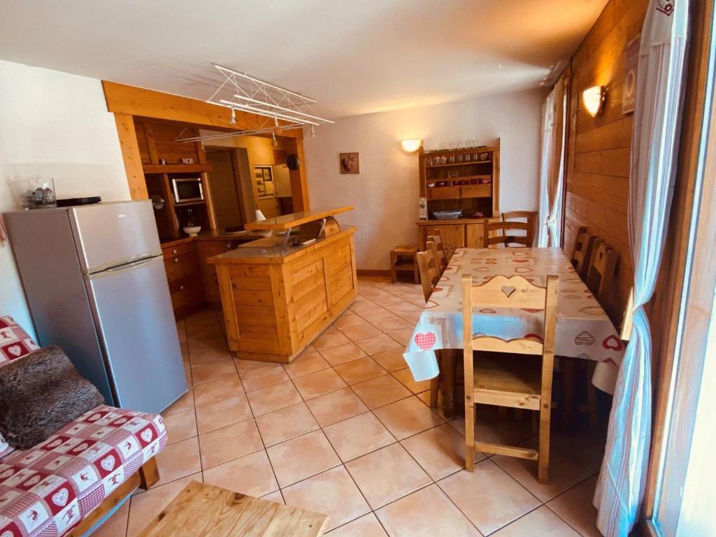 une cuisine et une salle à manger avec une table et un réfrigérateur dans l'établissement Appartement 3 pièces avec balcon et Wifi au centre de La Clusaz - FR-1-459-20, à La Clusaz