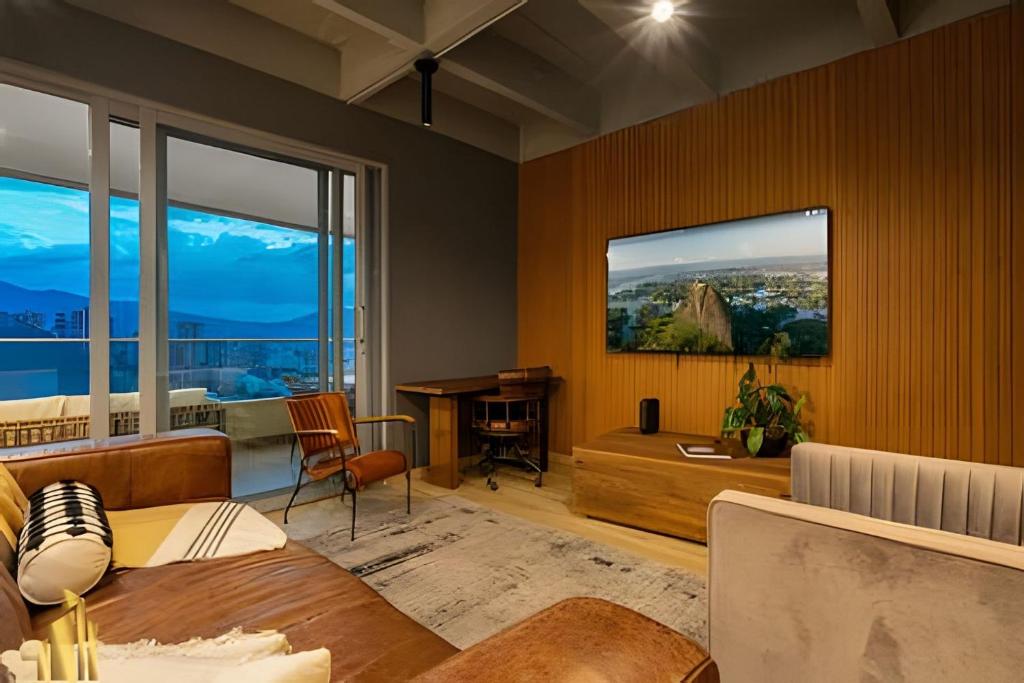 een woonkamer met een tafel en een bureau bij Life 1603 - Panoramic & Tastefully Decorated Loft in El Poblado