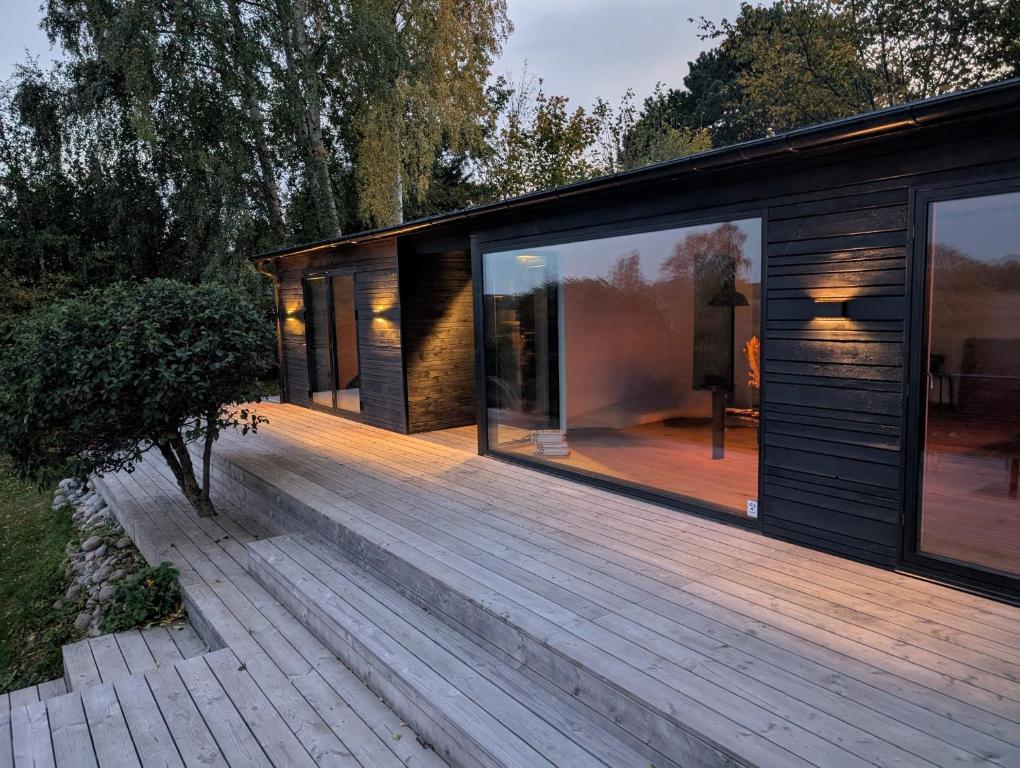 a modern house with a wooden deck at Nordic Designer Summerhouse - With a fantastic view in Vejby