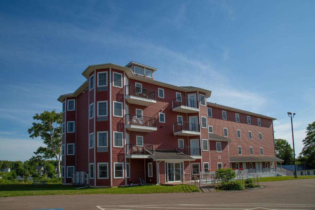 ein großes rotes Backsteingebäude mit Balkonen in der Unterkunft Lanes Riverhouse Inn & Cottages in Montague
