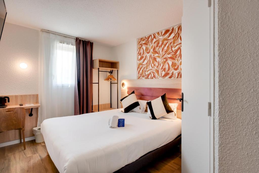 ブール・レ・ヴァロンスにあるSure Hotel by Best Western Valence Nordの大きな白いベッドと窓のあるホテルの部屋