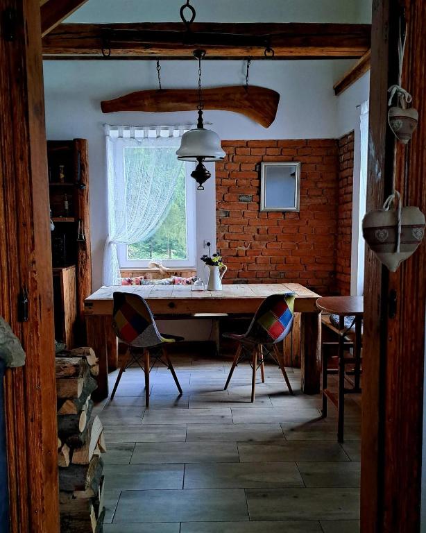 a dining room with a table and chairs and a window at Gospodarstwo agroturystyczne Ryznerówka in Posada Rybotycka