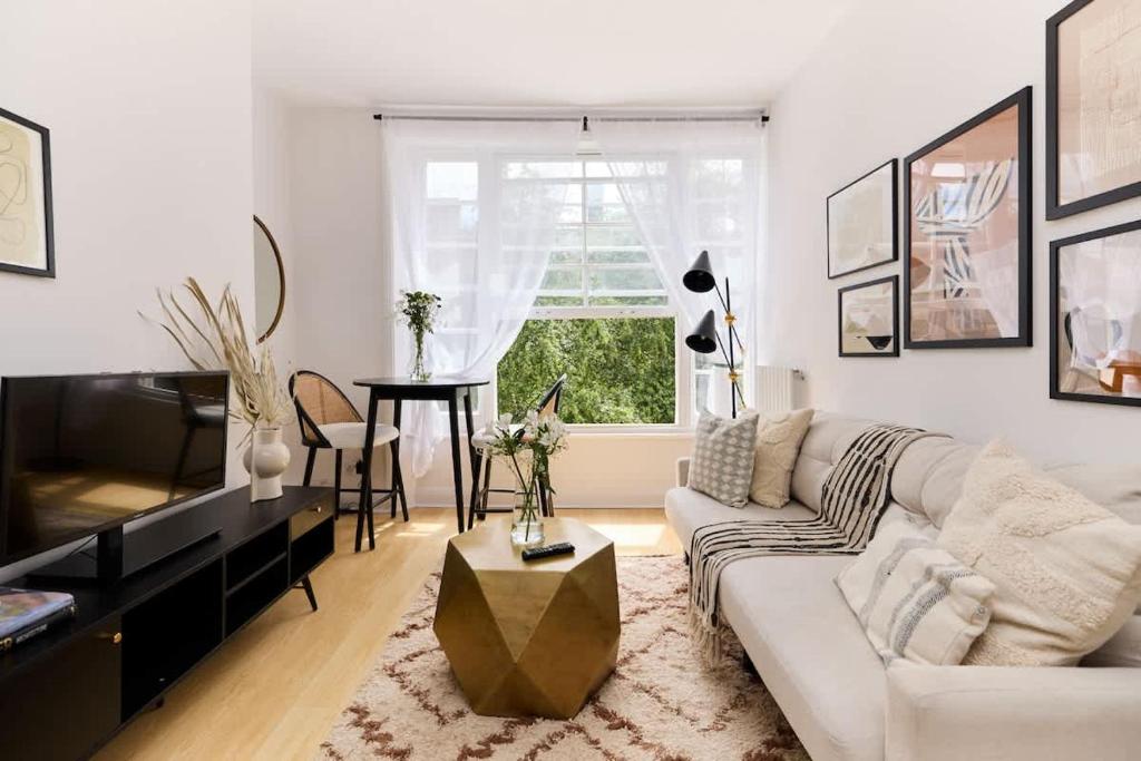a living room with a couch and a table at The Camden Hideout - Modish and Bright 2BDR Flat in London