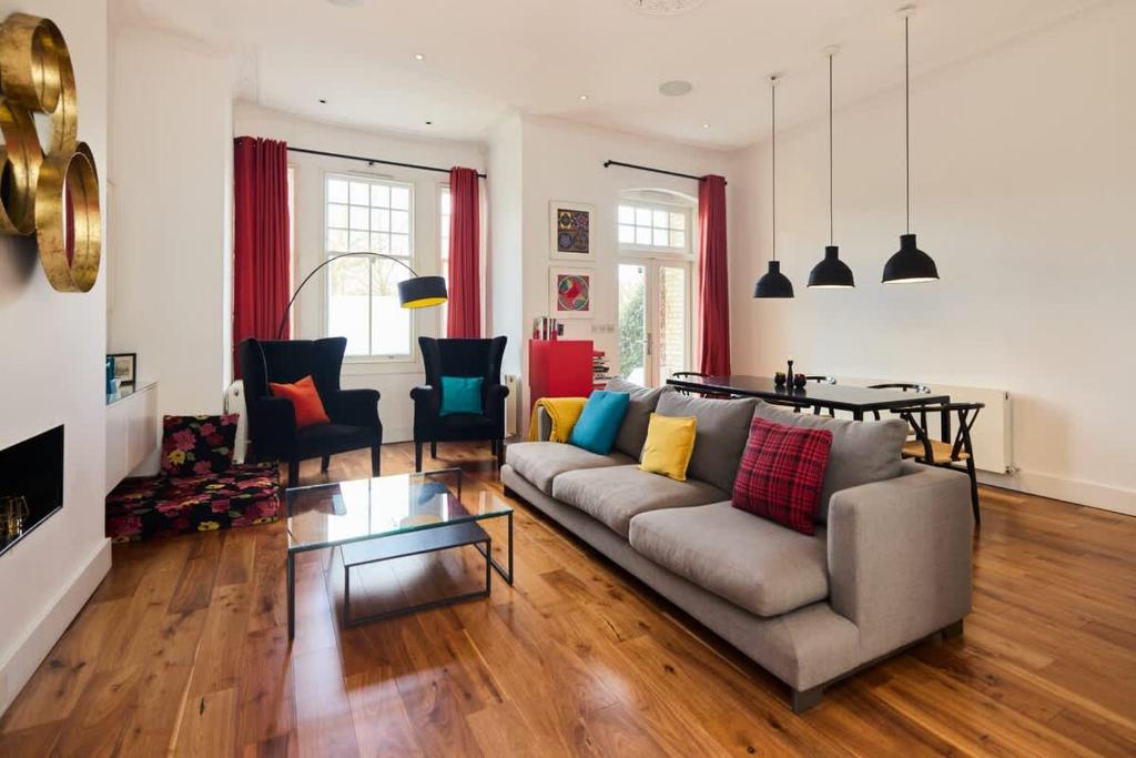 een woonkamer met een bank en een tafel bij The Clapham Crib - Spacious 4BDR House with Patio in Londen