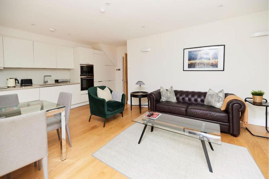 een woonkamer met een bank en een tafel bij The Bayswater Nook - Stylish 1BDR Flat in Londen