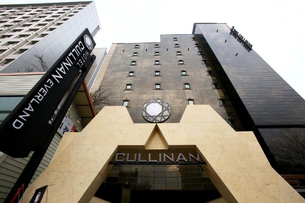 a building with a clock on the front of it at Hotel Cullinan Yongin in Yongin