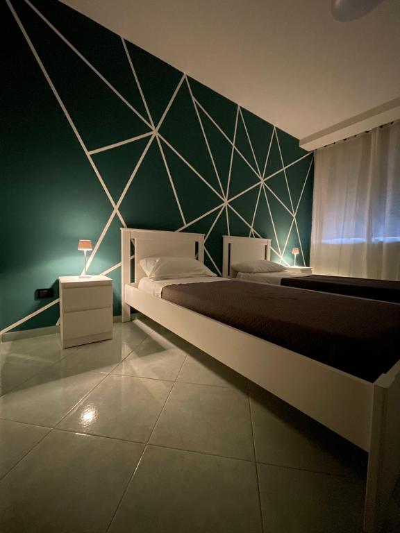 Un dormitorio con una cama y una pared verde. en Home24, en Casalnuovo di Napoli