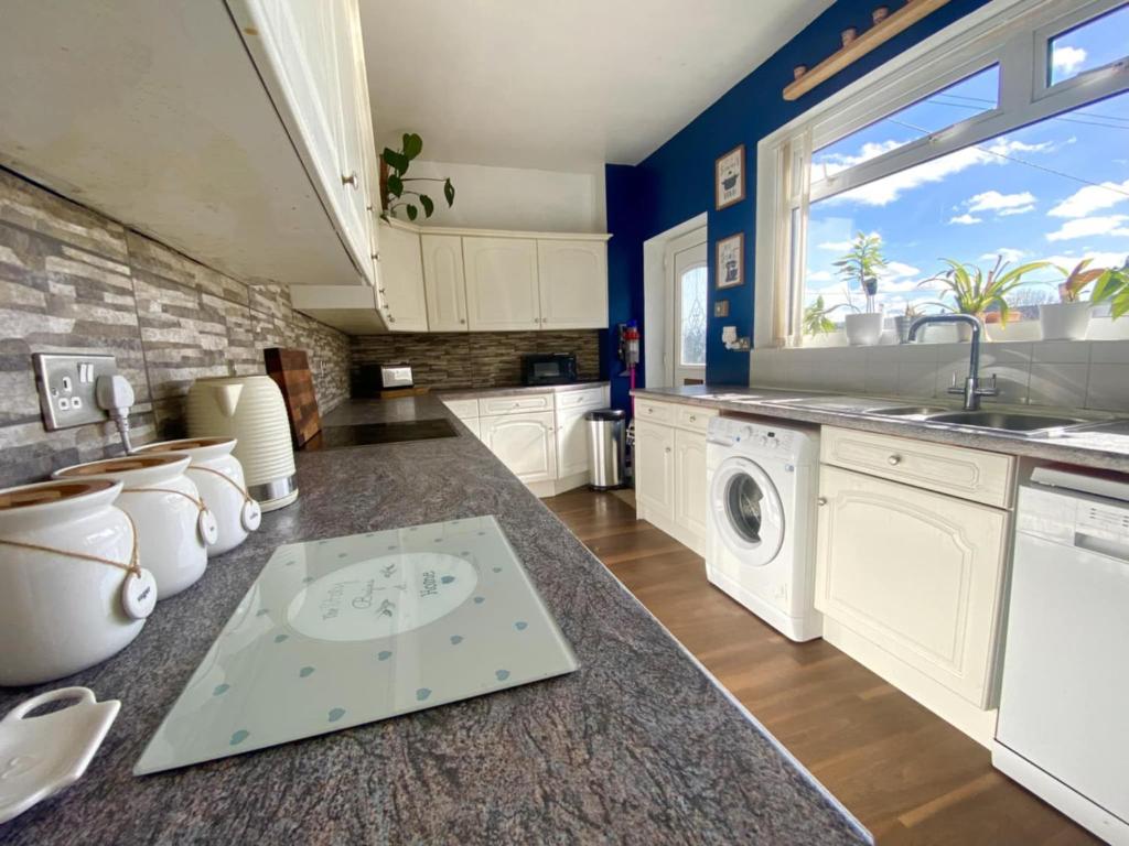 a kitchen with a sink and a washing machine at The Fell in Sacriston