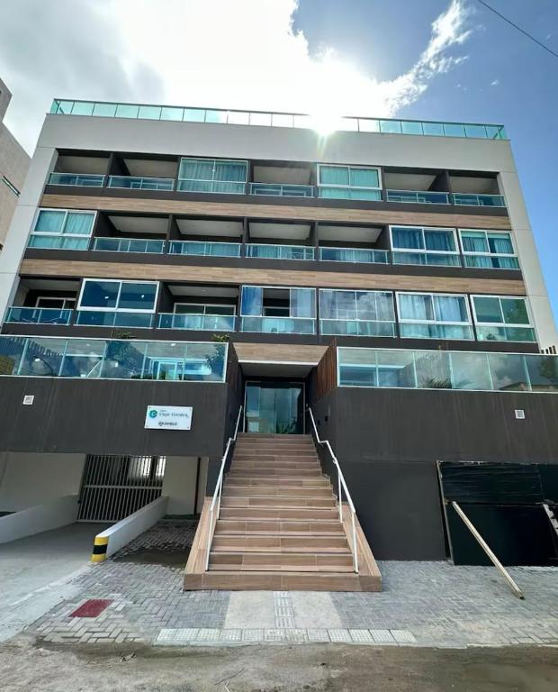 Un gran edificio con una escalera en el frente. en Flat aconchegante praia do cupe, en Ipojuca