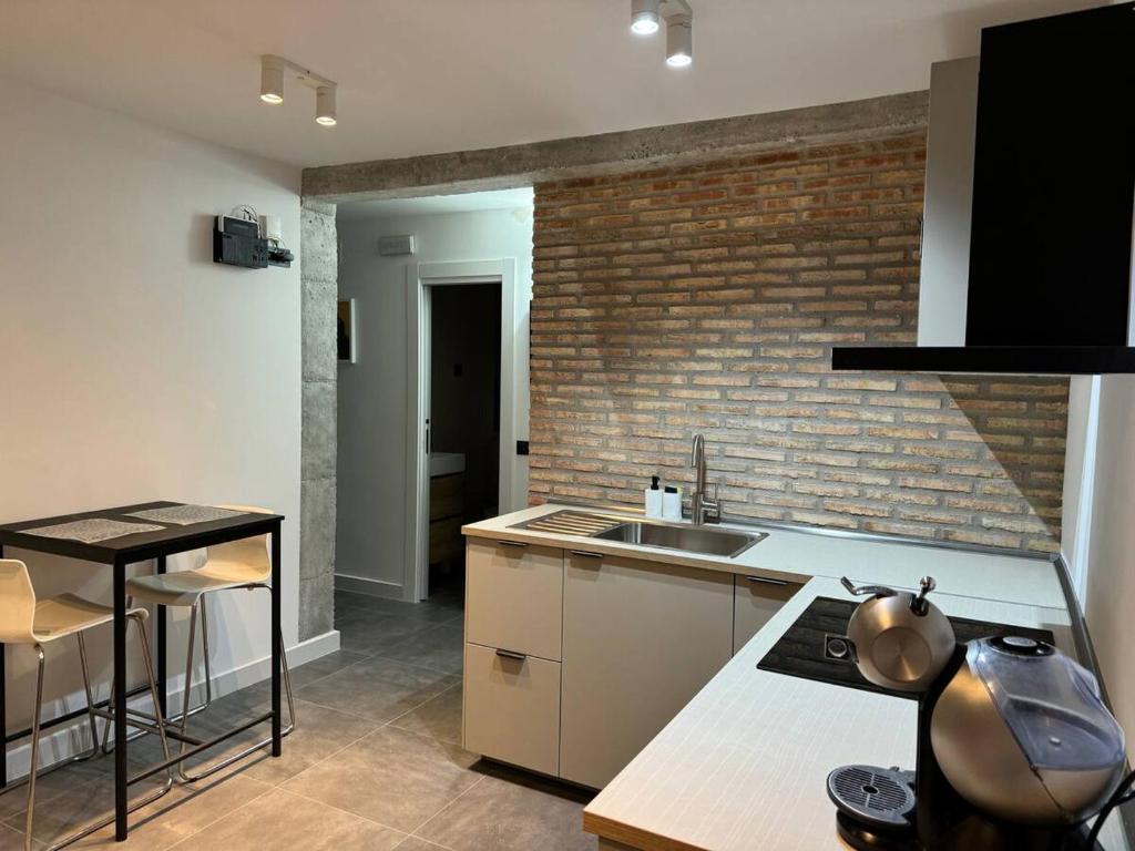 Cozy private room with shower #1 في مدريد: مطبخ مع حوض وجدار من الطوب