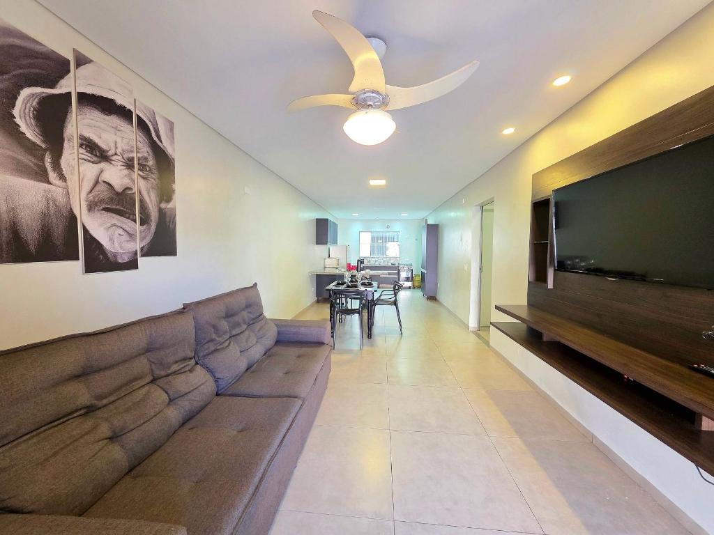 a living room with a couch and a flat screen tv at 2 quartos ao lado Gin Costa Cavalcanti 10 m centro in Foz do Iguaçu