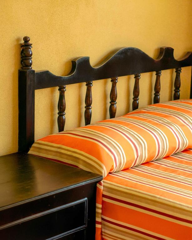 a bed with an orange and orange striped blanket at Hotel Gaviota Vallarta in Puerto Vallarta