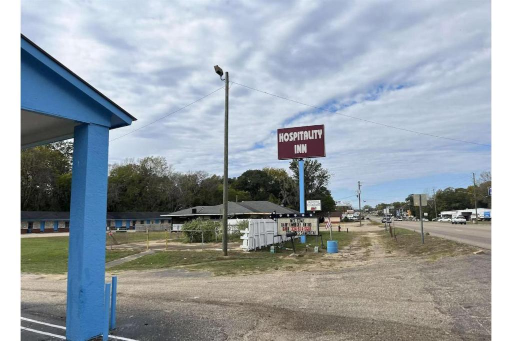 a sign for a hospital inn on the side of a road at Hospitality Inn By Belvilla Selma US 80 AL in Selma