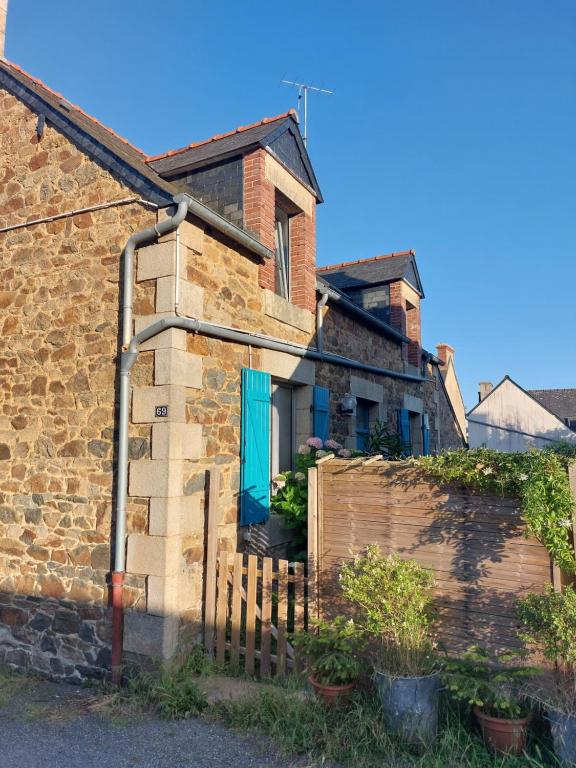 an old brick house with a blue door at Maison de village au Linkin in Perros-Guirec