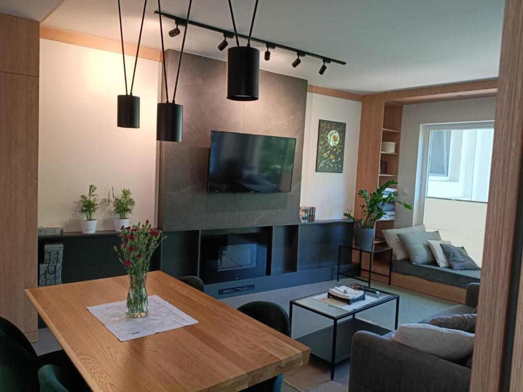 Una sala de estar con una mesa y un televisor. en Apartament Lena Stare Miasto, en Cracovia