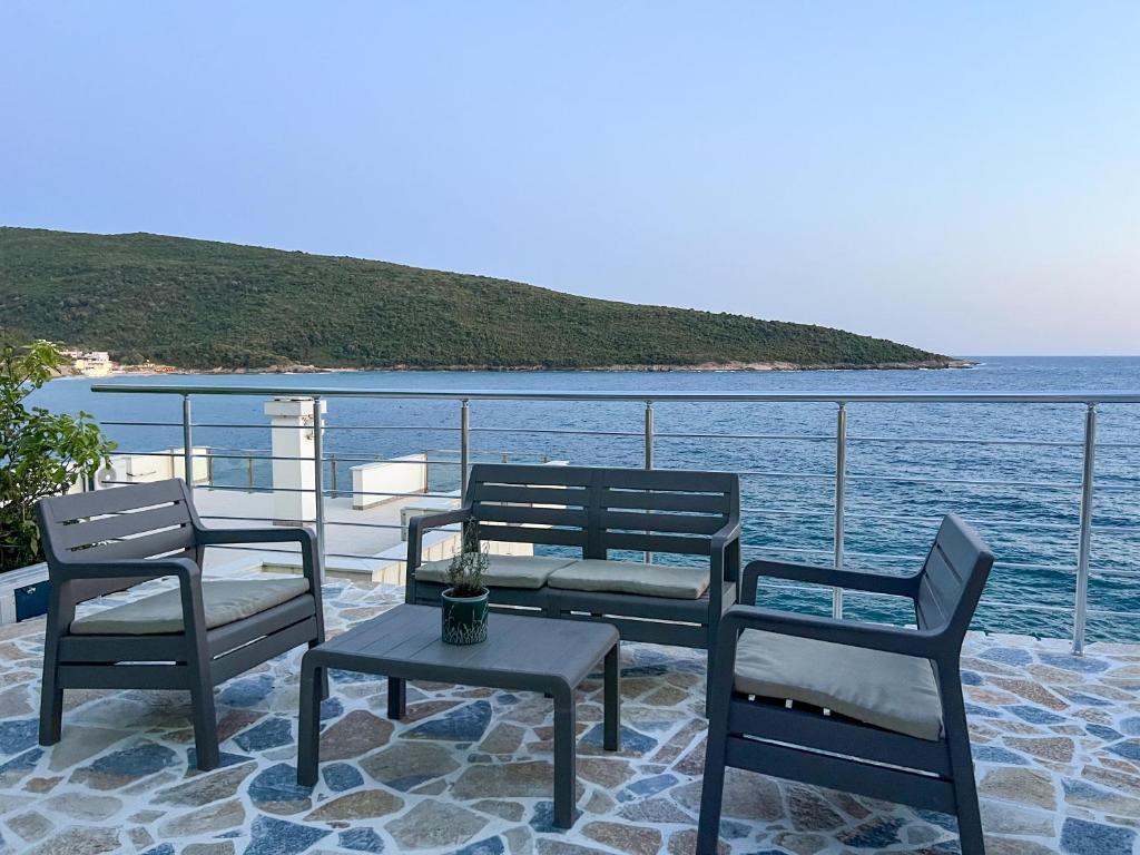 a group of chairs and a table on a balcony overlooking the water at Azzure Apartment in Ulcinj