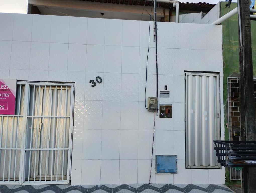 eine weiße Wand mit zwei Fenstern auf einem Gebäude in der Unterkunft Sol e mar in Fortaleza